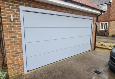 Light grey sectional door with matching front door